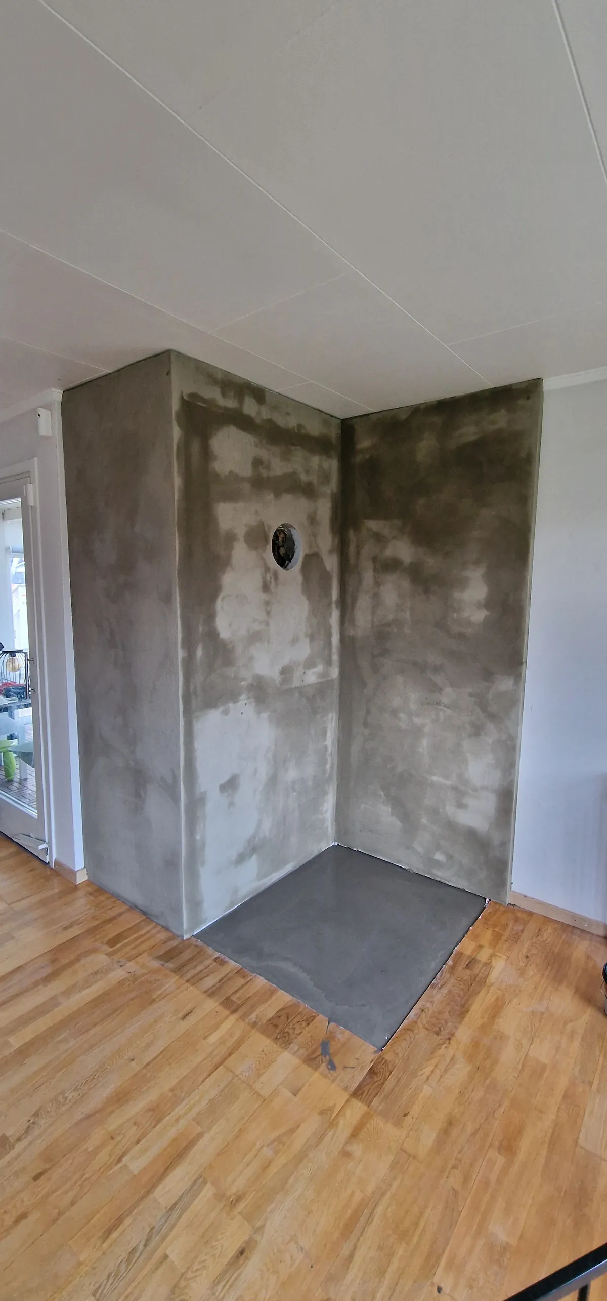 Grovpuss av mur før montering av vedovn på ny stålplate