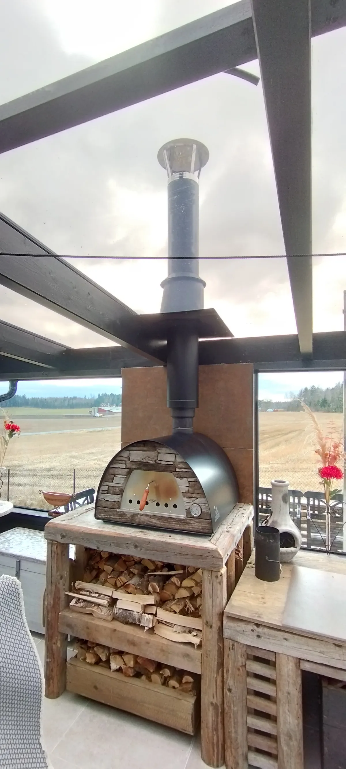 Isolert stålpipe montert på pizzaovn rundt beslag over tak