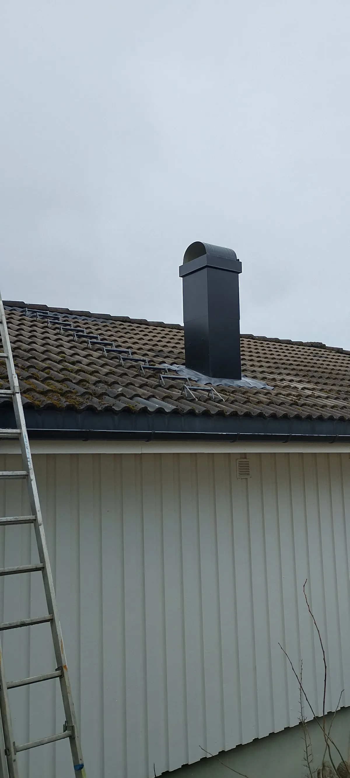 Moderne stålpipe på eldre takstein