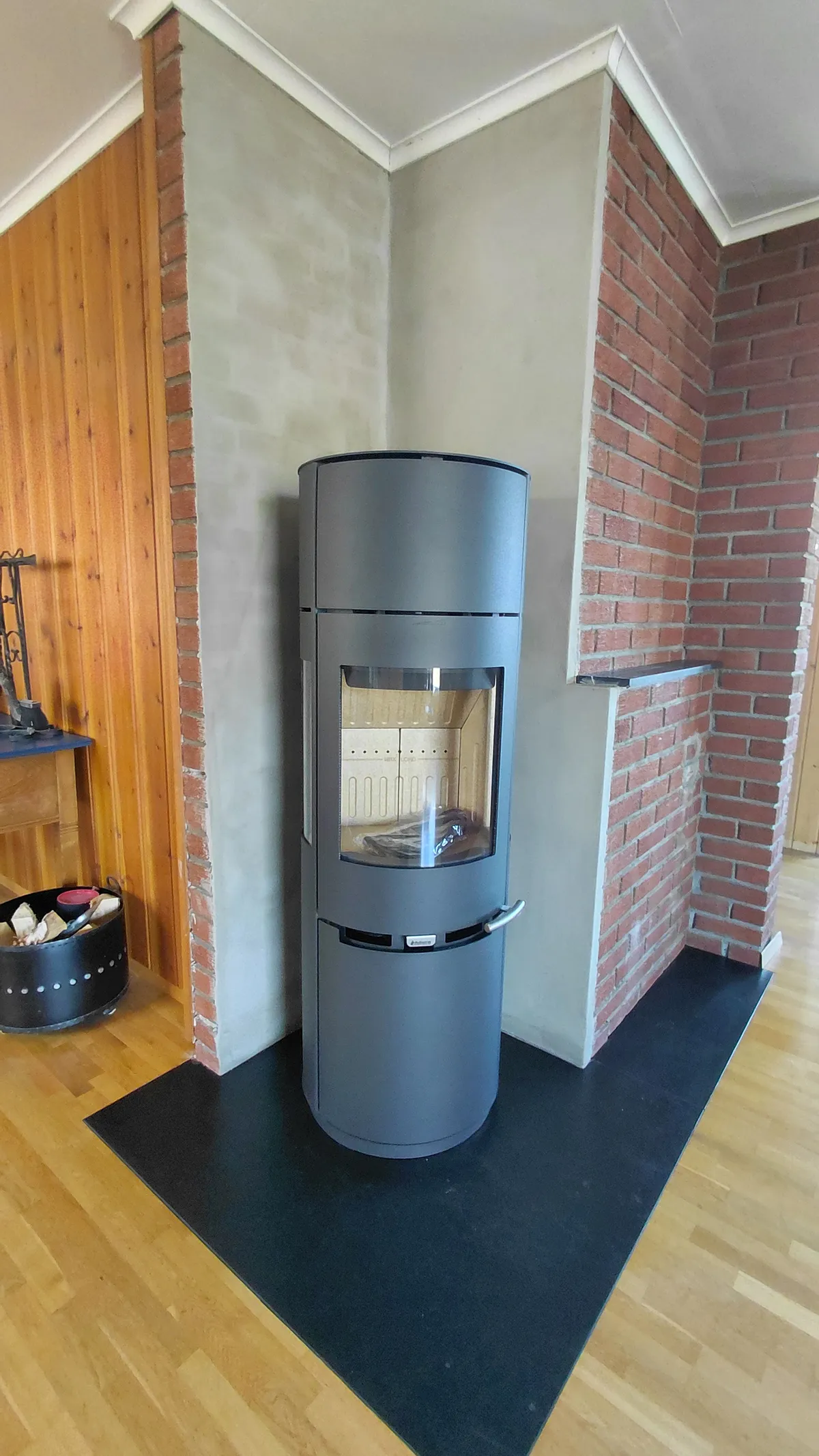 nærbilde av aduro vedovn montert på ny skiferplate og pusset mur