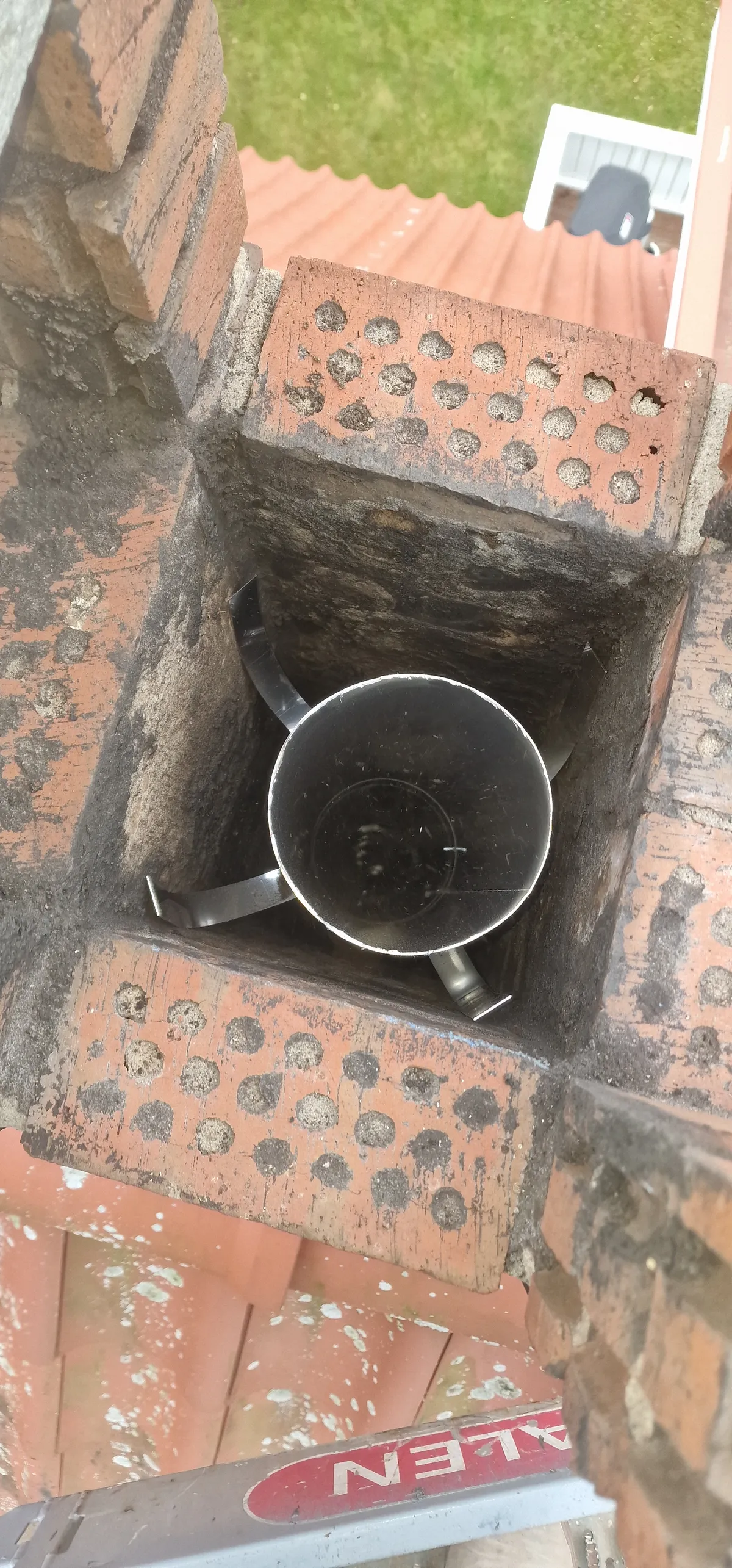 Nye stålrør i pipe før toppbeslag i gammel teglskorstein