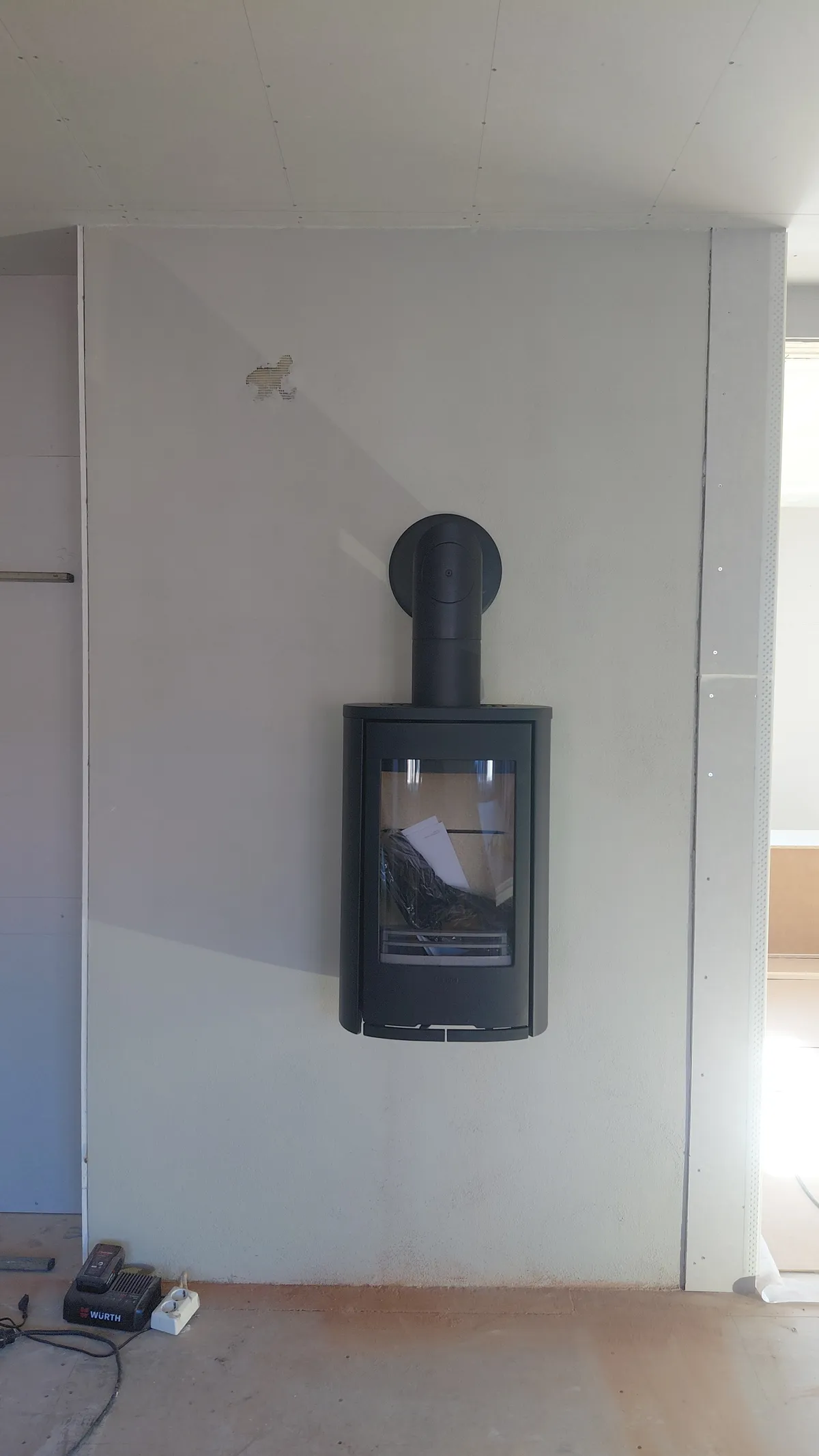 Rehabilitert pipe med vegghengt Contura vedovn på tegl