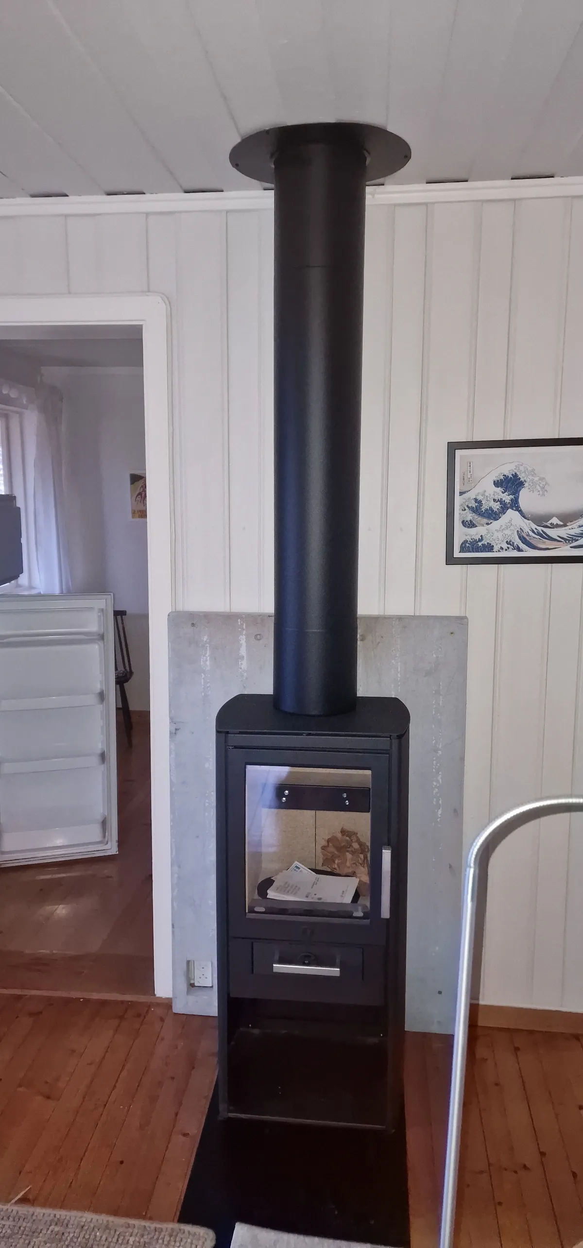 Vedovn montert med stålpipe på liten hytte